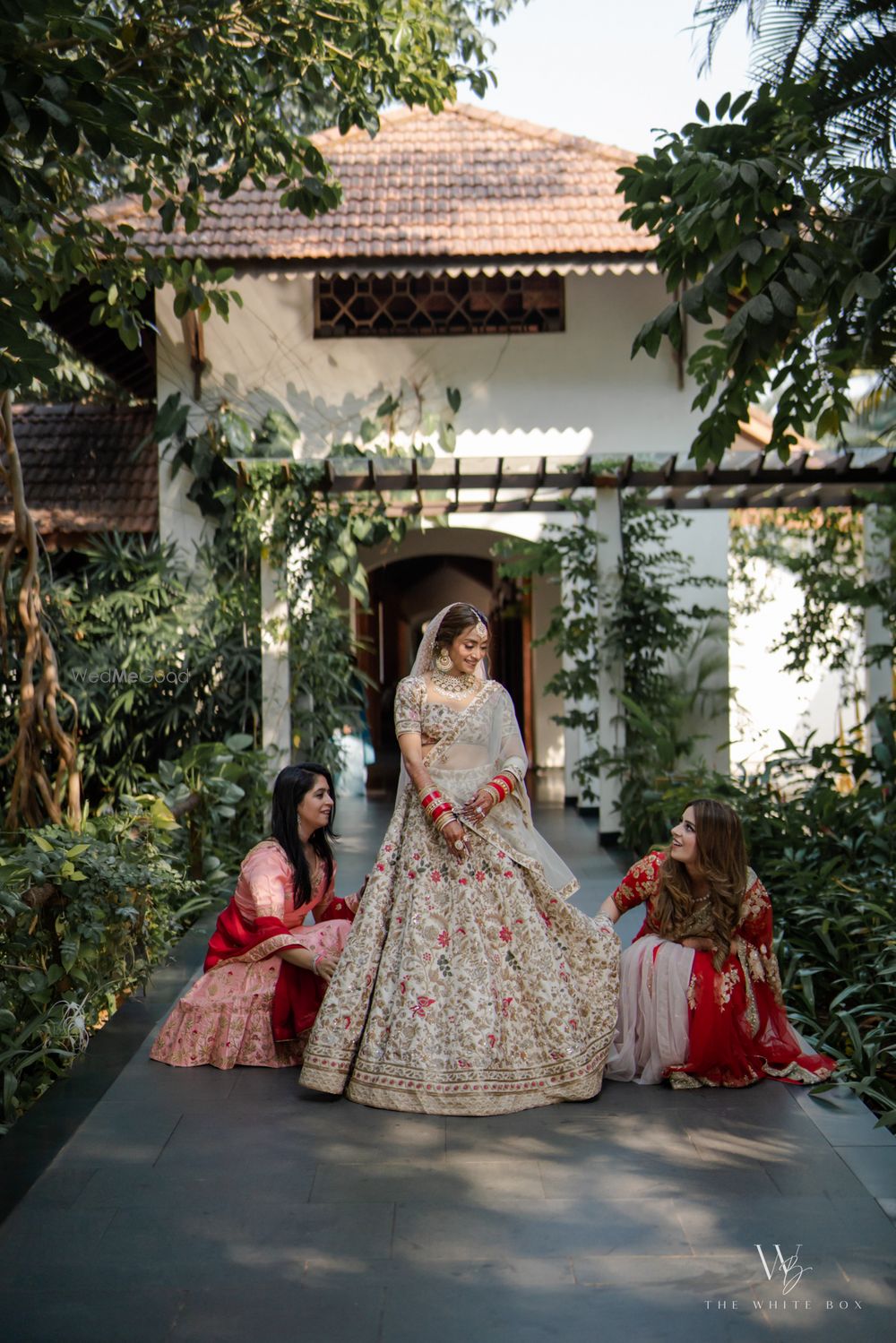 Photo of Lovely shot of the bridesmaids adjusting the bride's lehenga