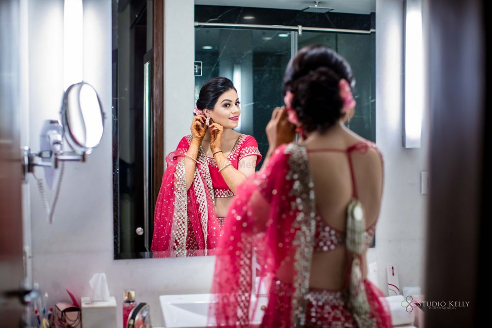 Photo of bride looking into mirror fixing hair shot