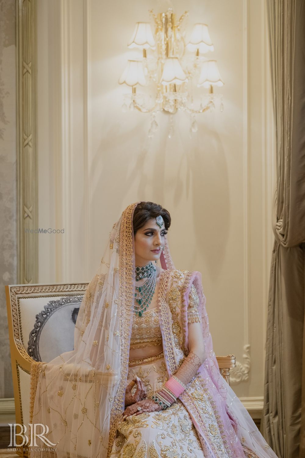 Photo of pastel pink bridal lehenga with unique blouse and green jewellery