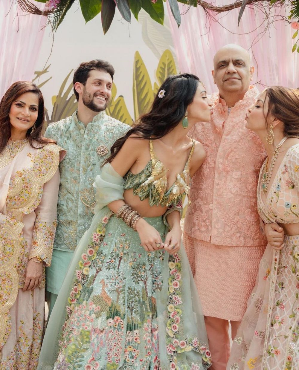 Photo of Alanna & Ivor with family in pastel outfits on their Mehendi