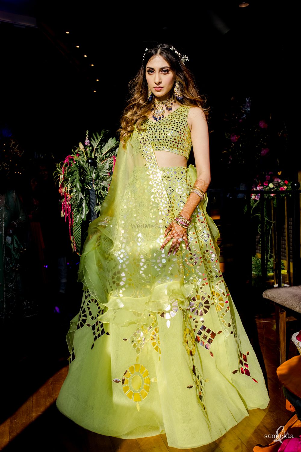 Photo of bride in lime green lehenga on her mehendi with open wavy hair