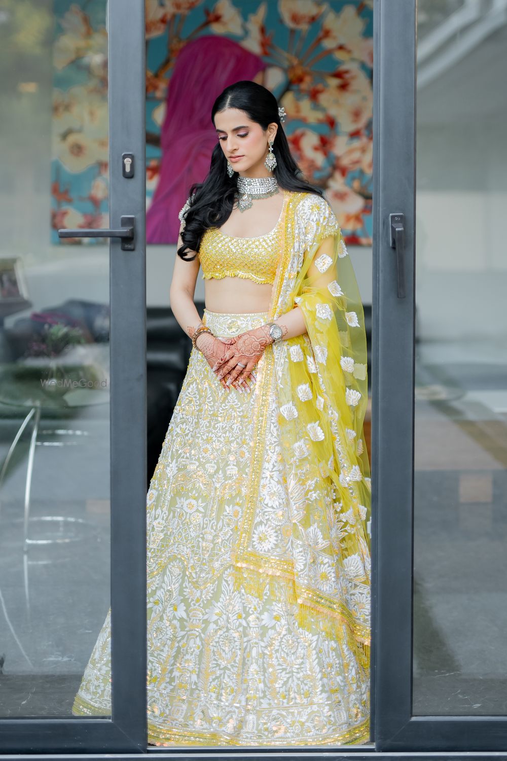 Photo of Lovely shot of the bride in a silver and yellow lehenga for her mehendi event with diamond and jade jewellery