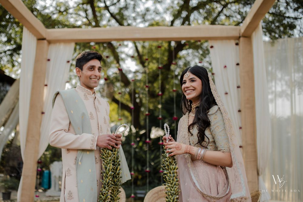 Photo of wedding day couple holding varmalas.