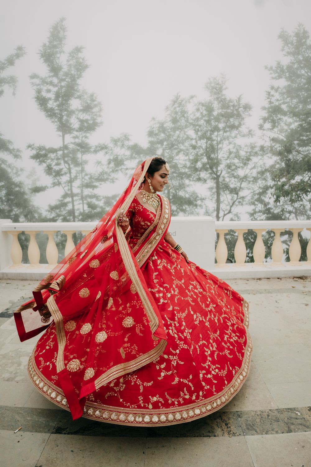 Photo of Bride twirling in a red Sabyasachi lehenga