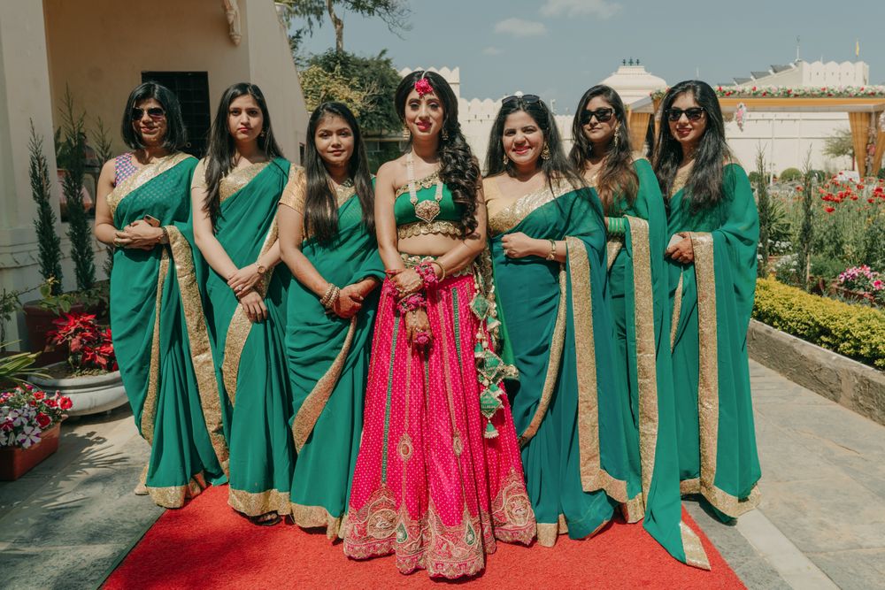 Photo of Bride posing with her color-coordinated bridesmaids.
