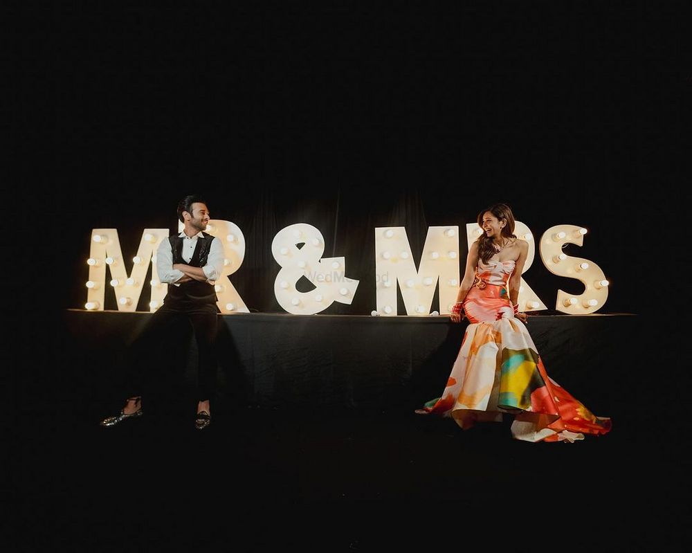 Photo of Fun Mr and Mrs signage from the reception decor with the couple posing in front
