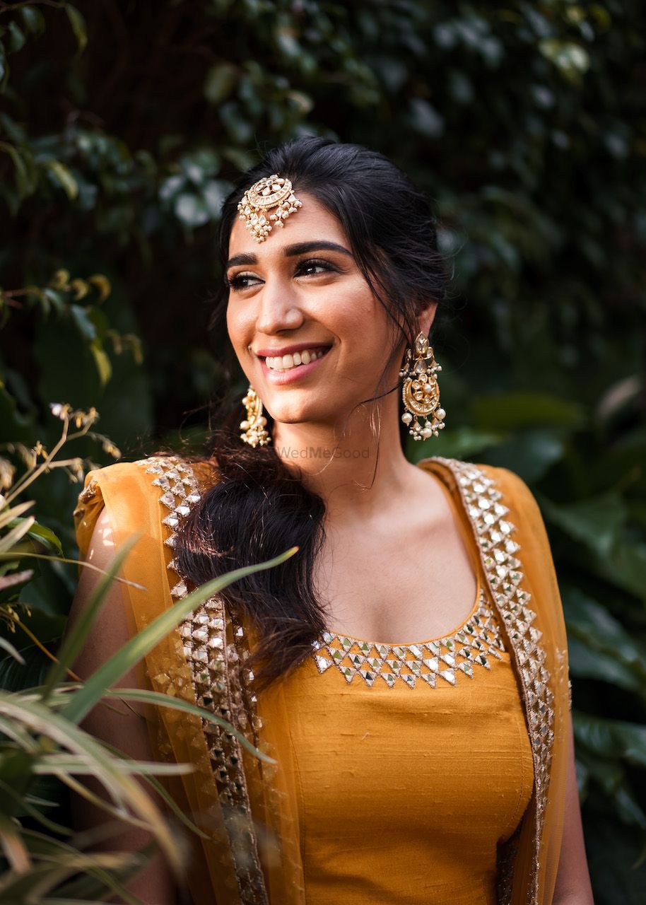 Photo of Bride wearing a yellow sharara suit on her Mehendi.