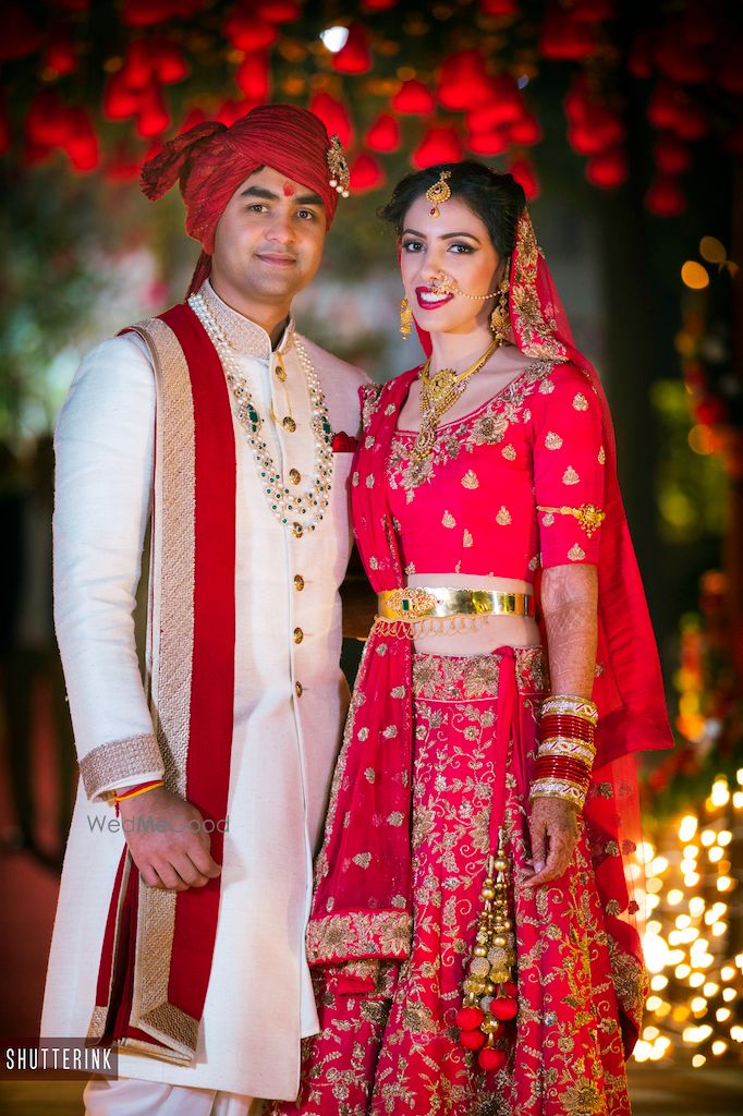 Photo of Red floral lehenga with gold waist belt