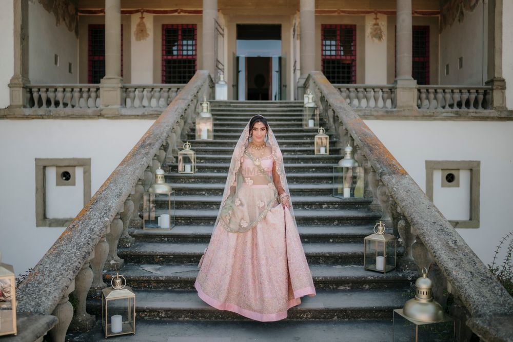 Photo of bride walking down the aisle in a pastel lehenga