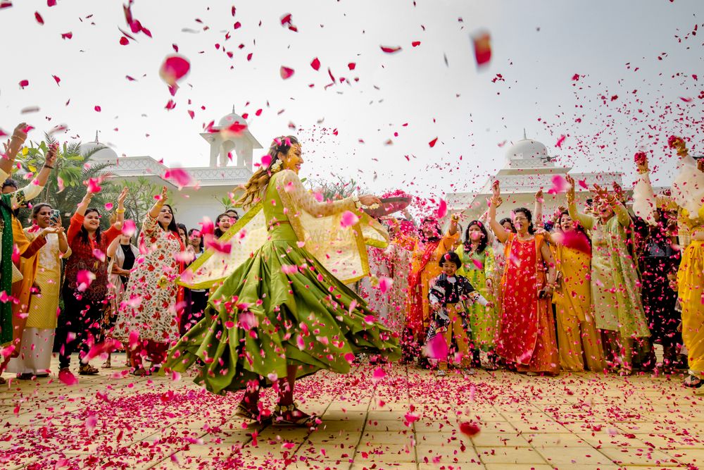 Photo of Bride twirling around and showering flower petals like confetti.