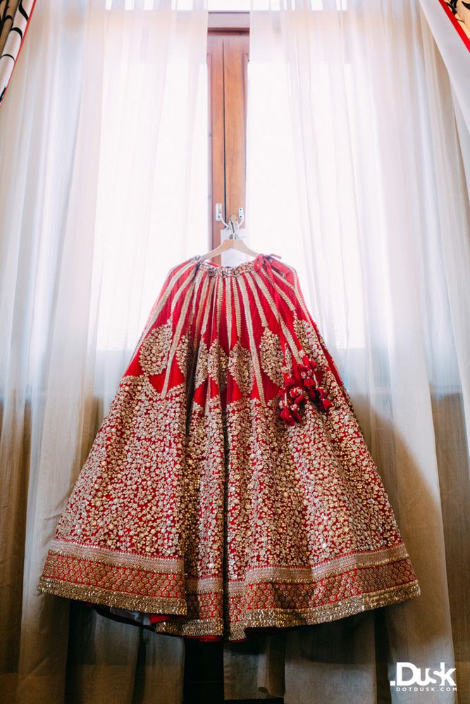Photo of Red bridal lehenga hung on hanger