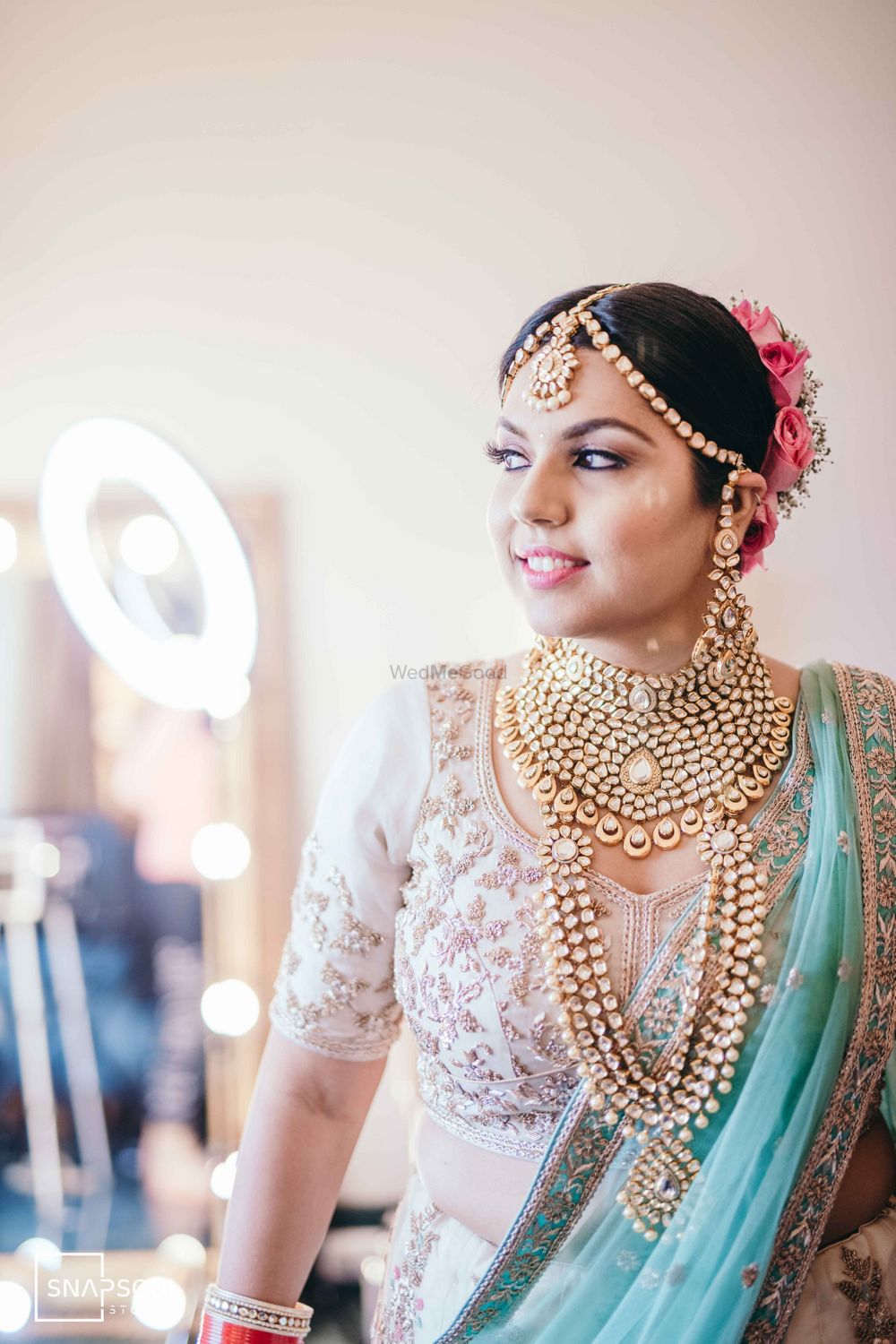 Photo of A happy bride in heavy gold jewellery.