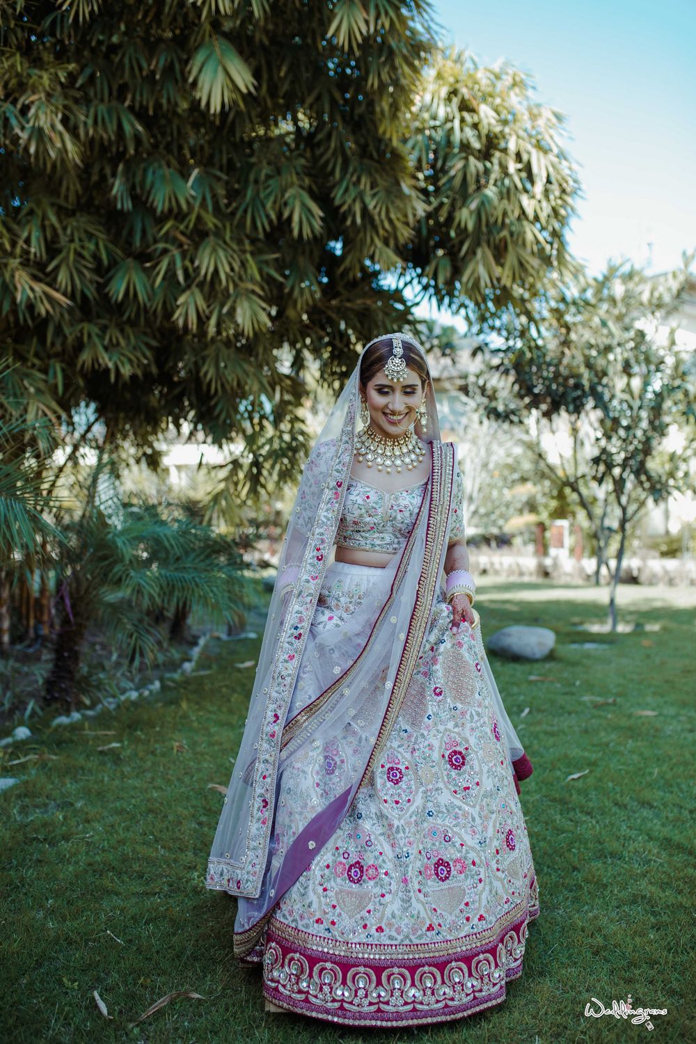Photo of bride in a white and red floral work lehenga with double dupatta