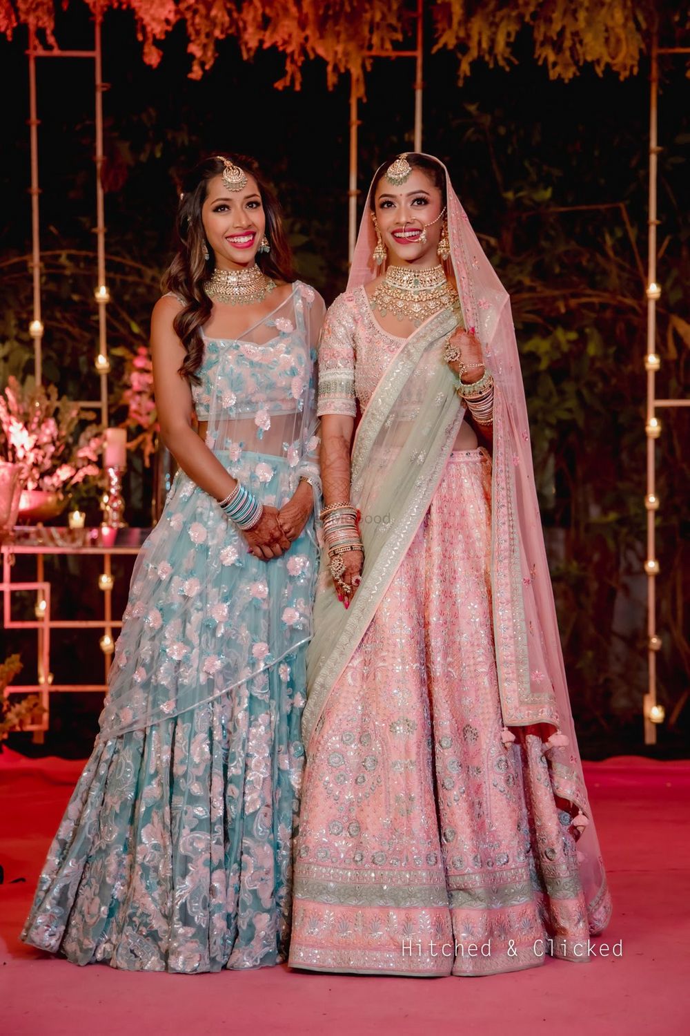 Photo of bride with her sister wearing contrasting outfits