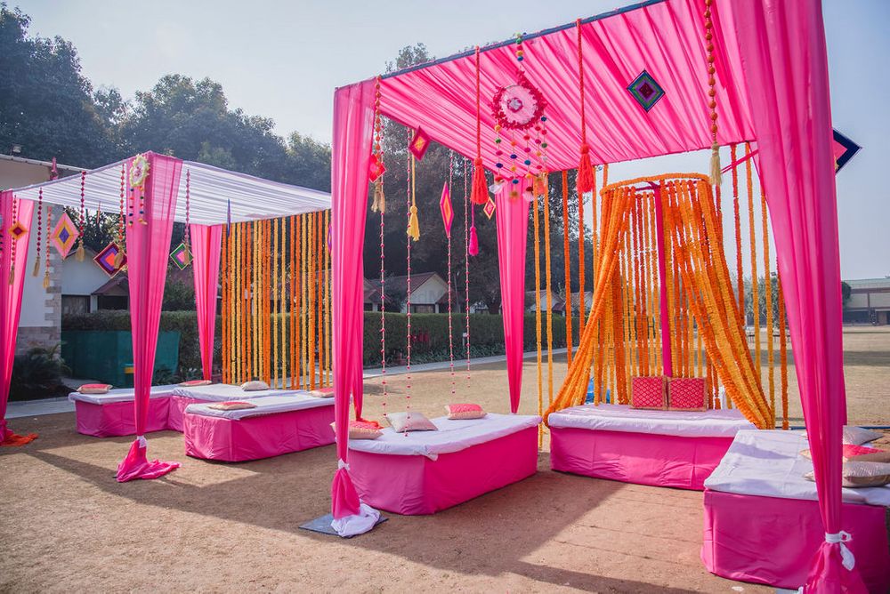 Photo of Mehendi decor idea with seating with pink and orange theme