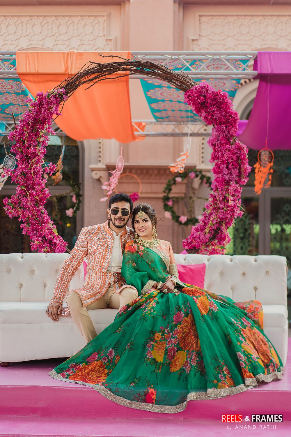 Photo of A bride and groom in colorful and coordinated outfits for their mehndi