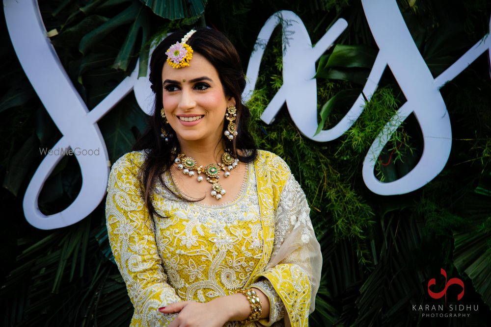 Photo of Bride on her mehendi in a bright yellow lehenga