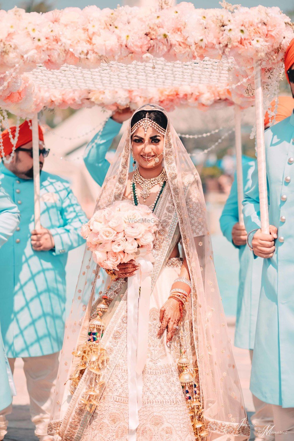 Photo of Bride under peach phoolon ka chadar with bouquet