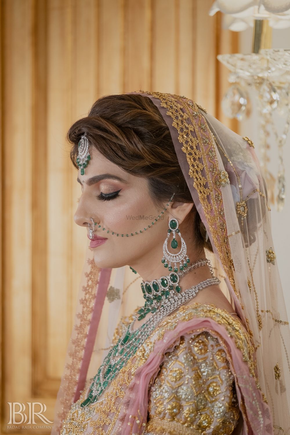 Photo of bride with glossy bridal makeup and emerald jewellery