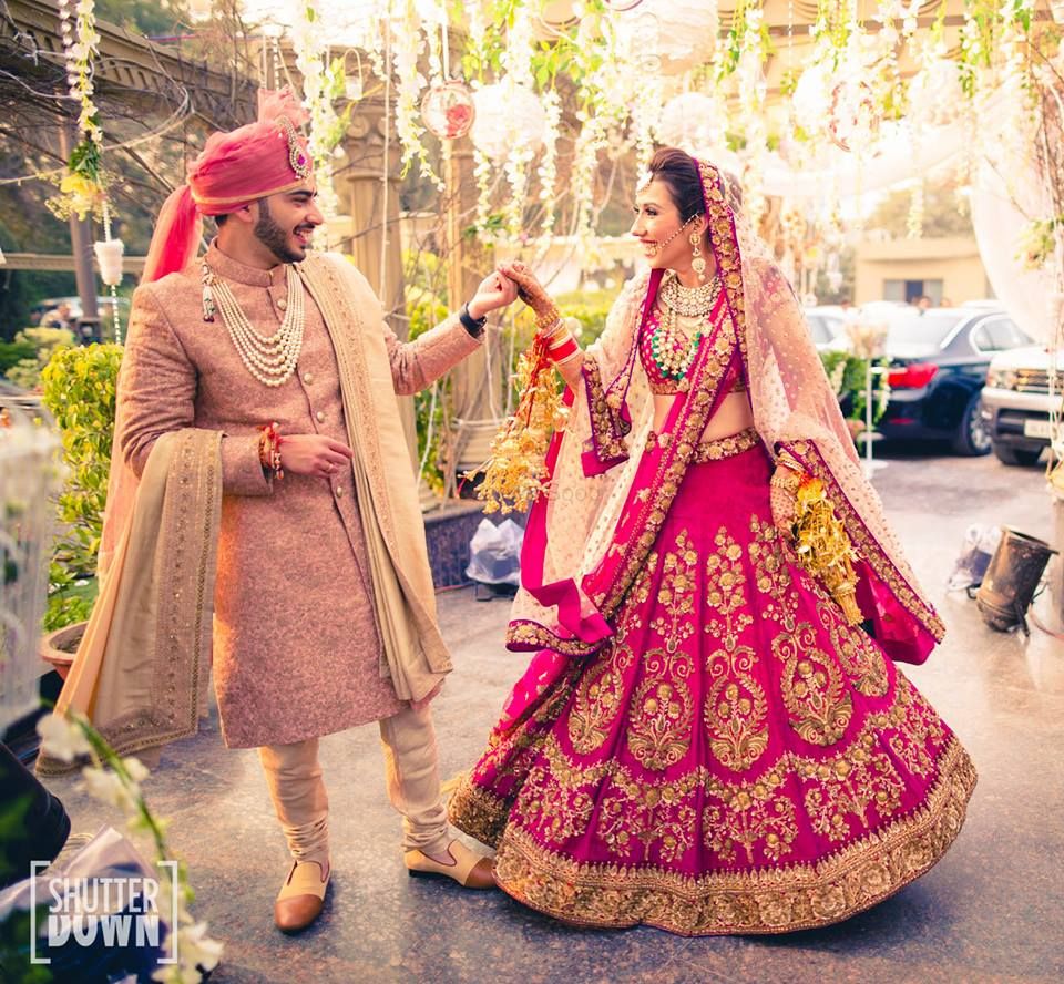 Photo of Bride and groom in fuschia pink coordinated outfits