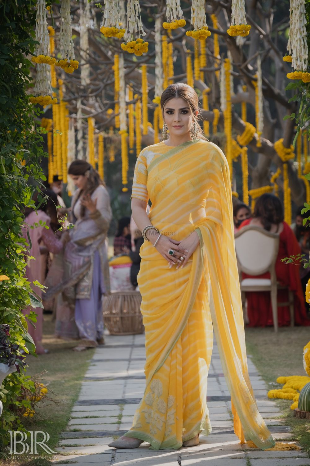 Photo of sister of the bride in yellow striped saree on mehendi