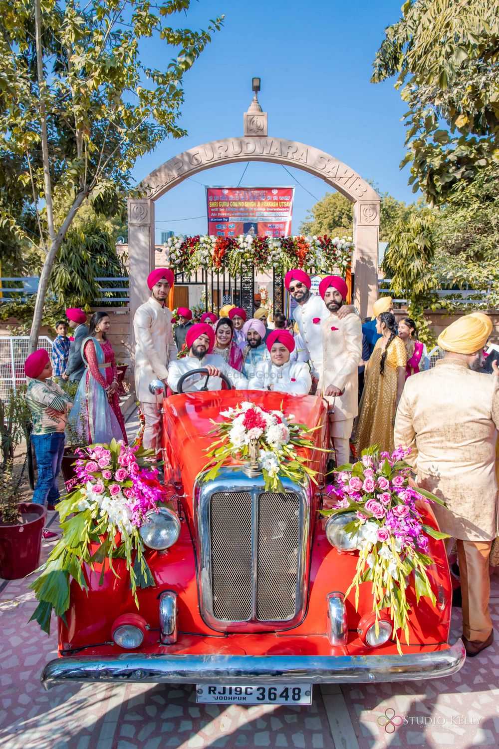 Photo of groom entry with entire family in vintage car