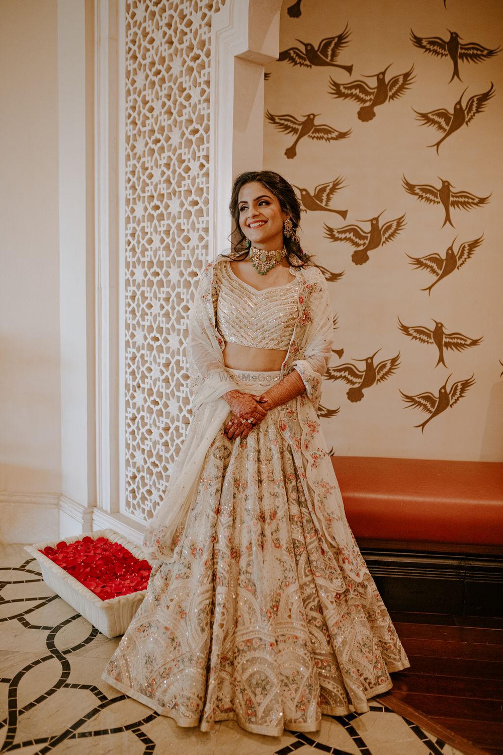 Photo of Bride wearing a detailed ivory lehenga on her Mehendi