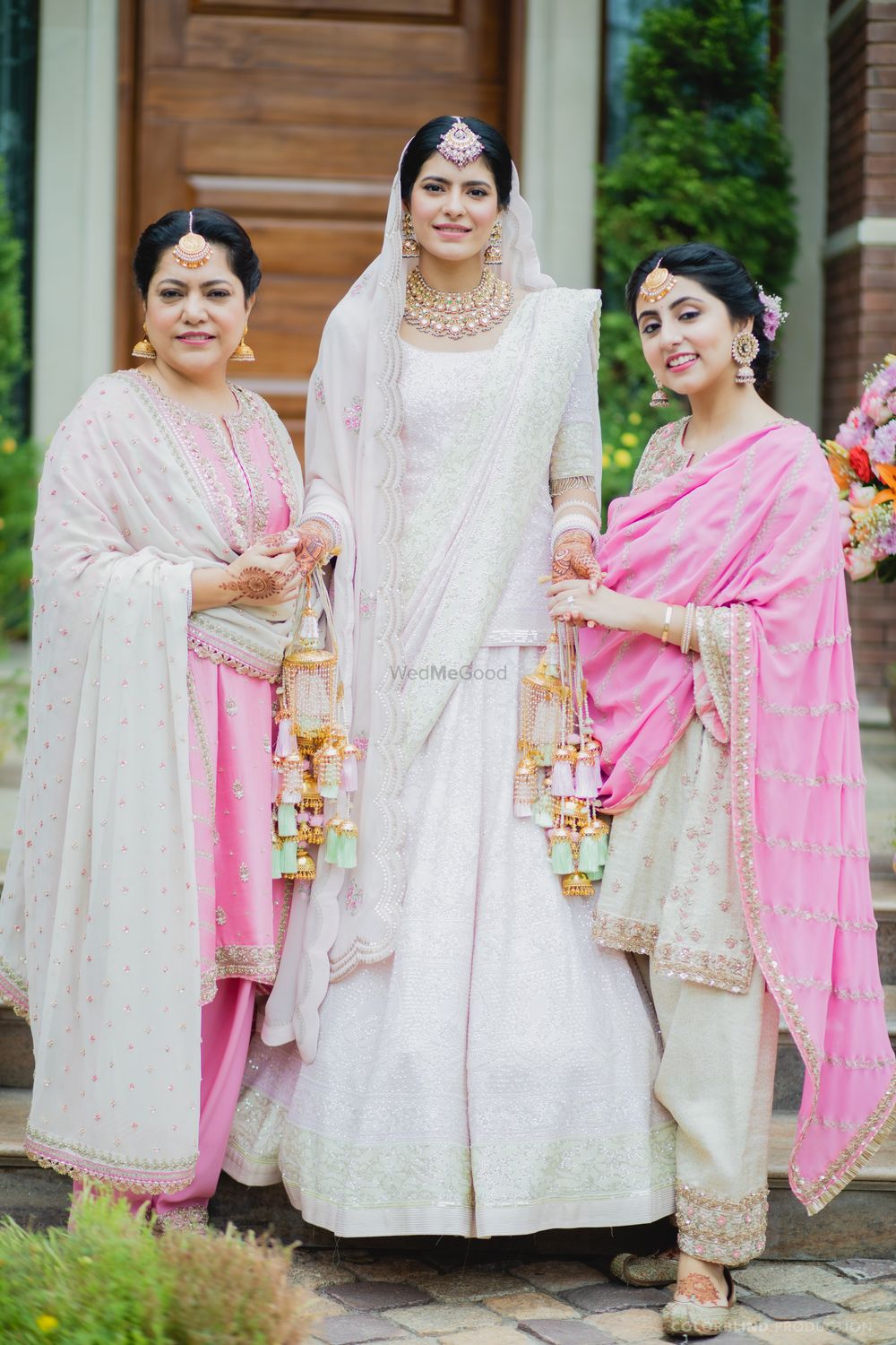 Photo of bride with mom and sister all in pastels