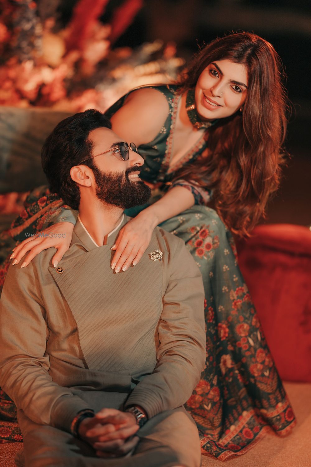 Photo of Fun couple capture with the groom in an olive coloured outfit and bride in a bottle green printed lehenga