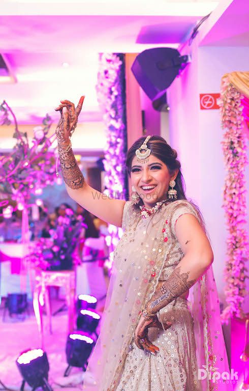 Photo of Dancing bride in beige lehenga