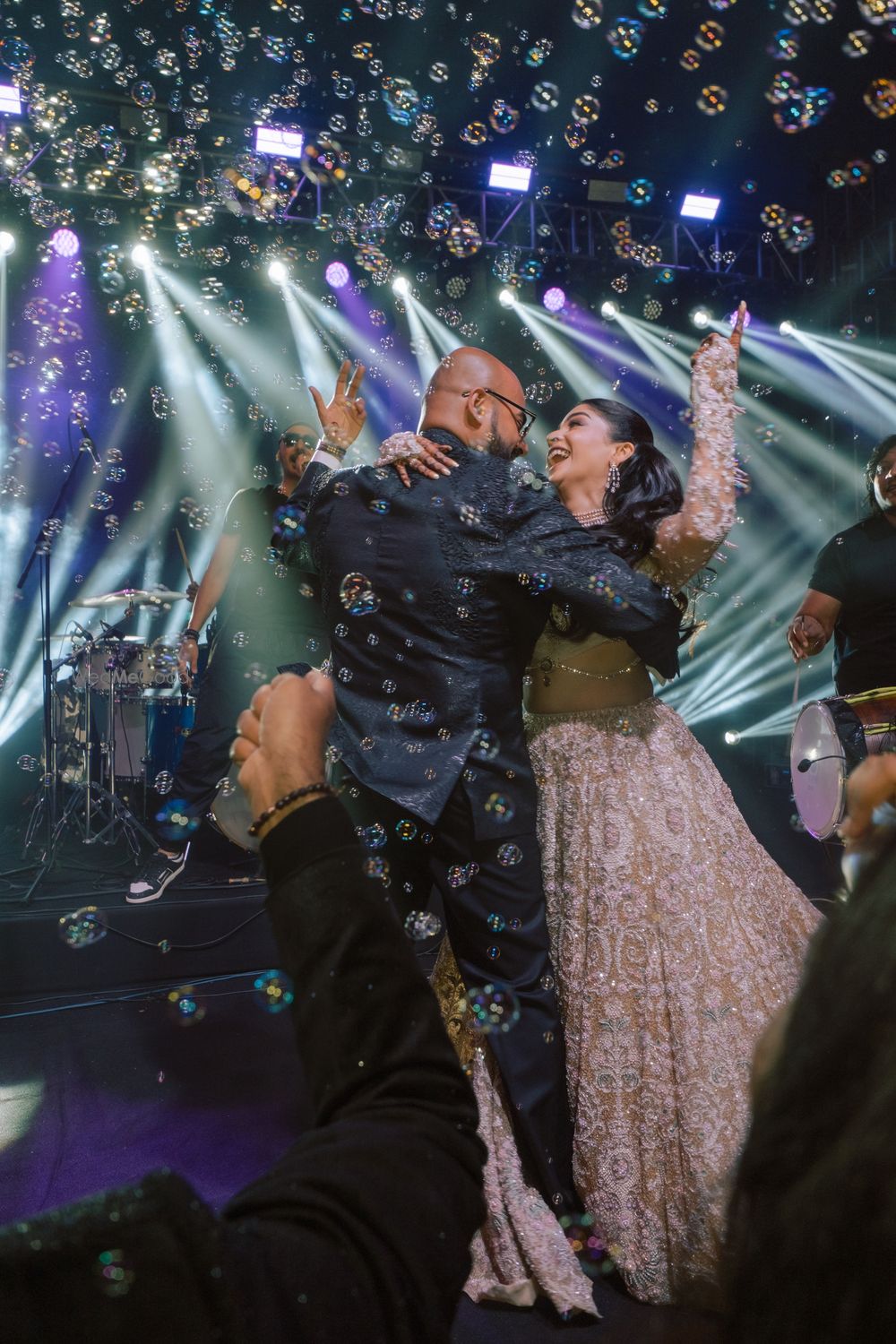 Photo of Fun candid capture of the bride and groom dancing on the sangeet amongst bubbles
