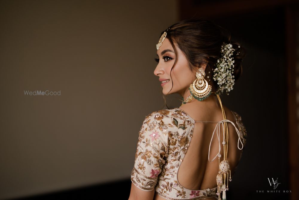 Photo of Stunning bridal portrait on the bride looking back and a lovely baby breath bridal bun