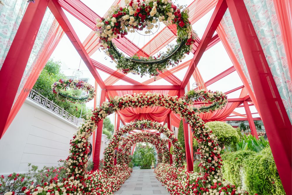 Photo of White, red and green themed floral entrance decor with floral chandeliers.