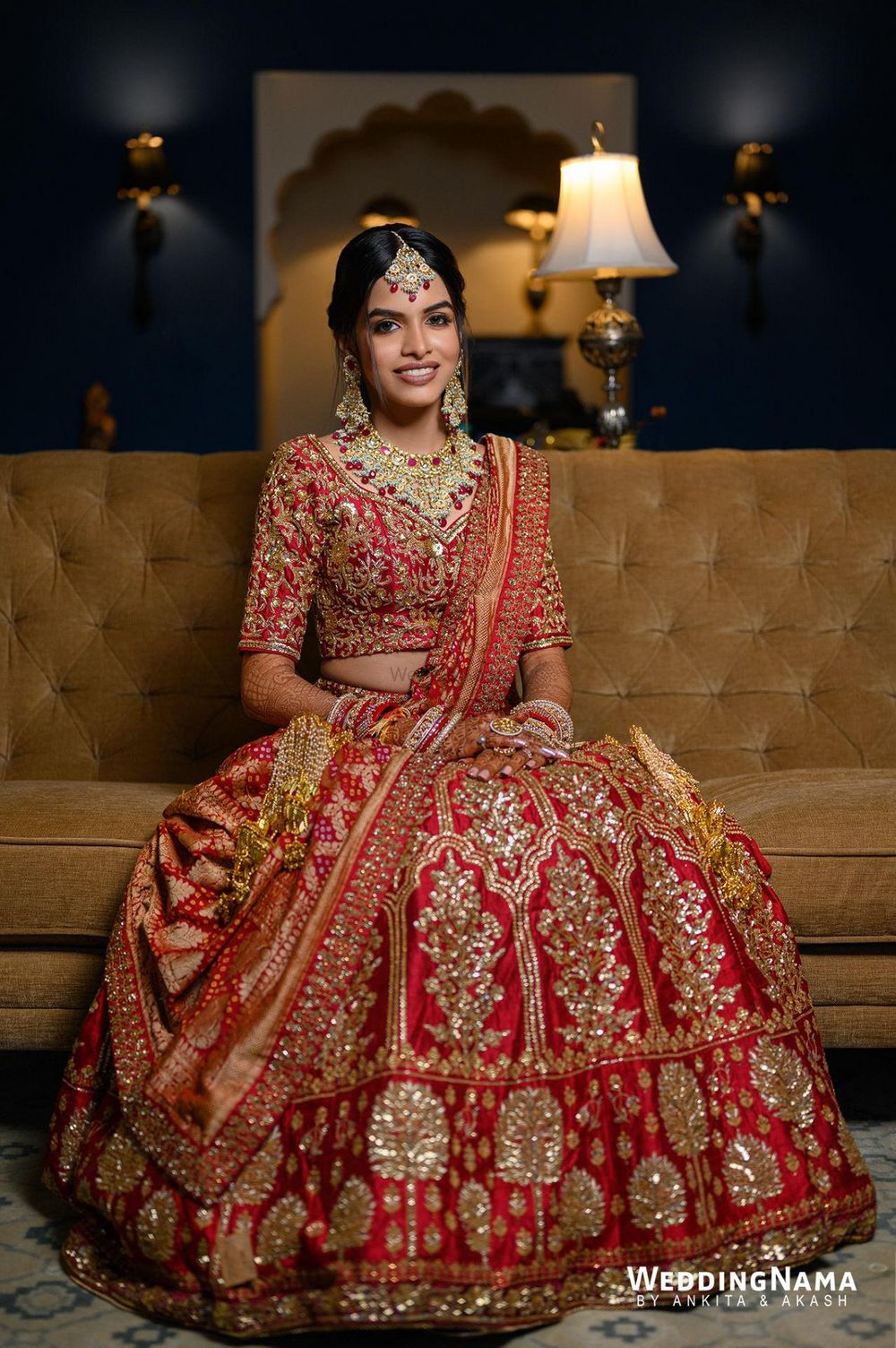 Photo of bride wearing a regal red and gold lehenga
