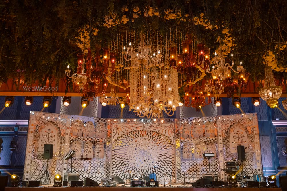 Photo of Grand decor for the sangeet stage with chandelier and florals