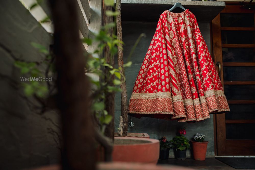 Photo of Sabyasachi bridal lehenga on hanger red and gold