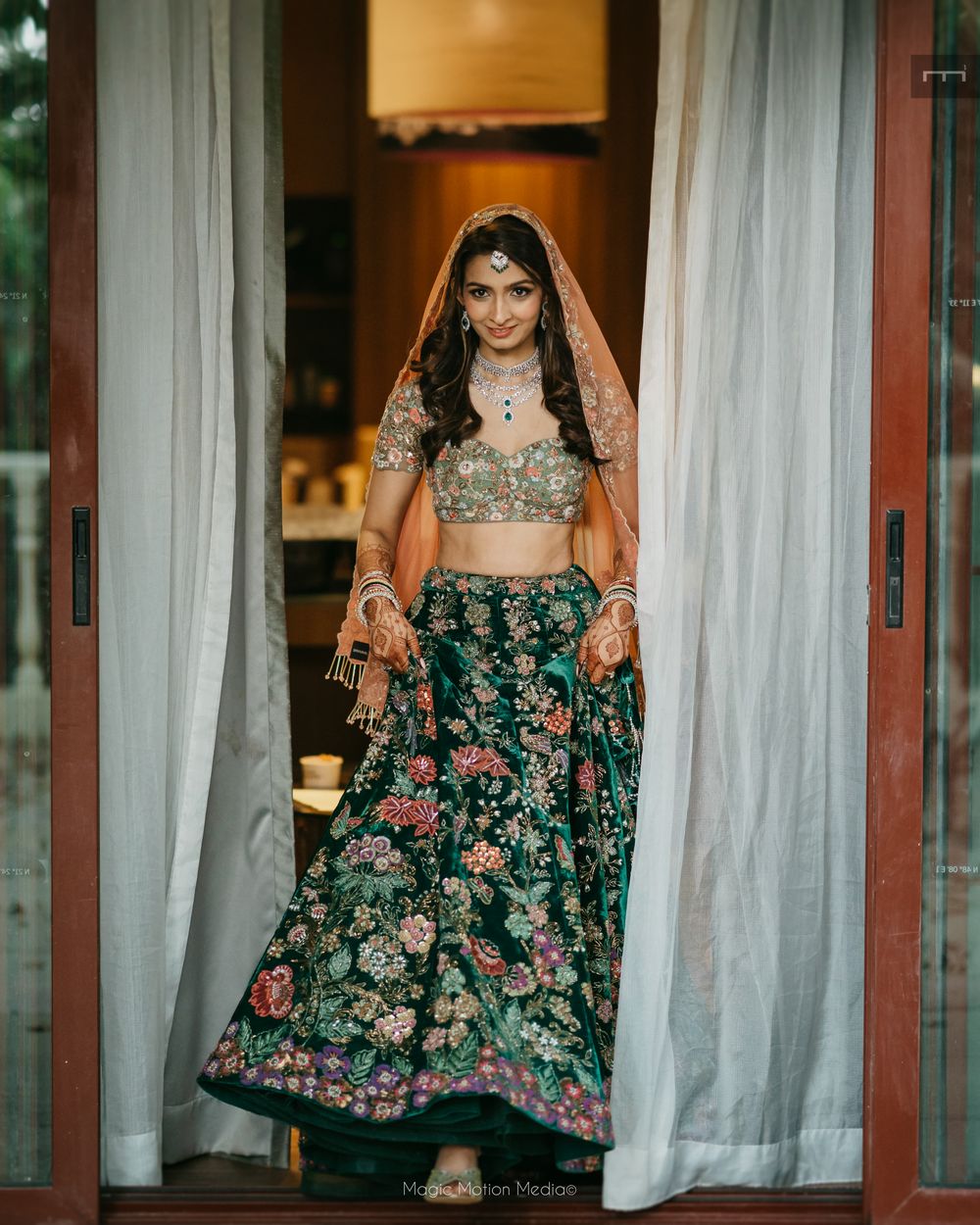 Photo of Beautiful bottle green hued velvet lehenga with floral embroidery all over with a peach dupatta.