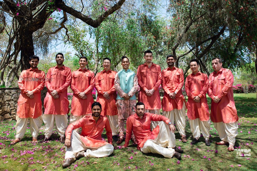 Photo of A groom with his groomsmen in coordinated outfits