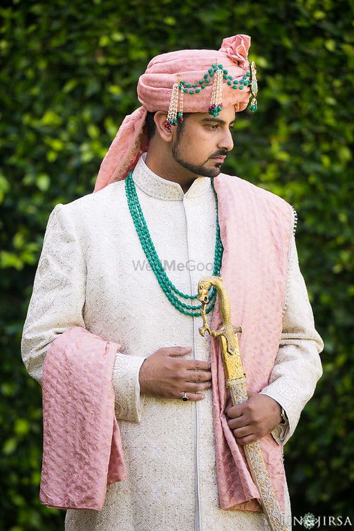 Photo of Groom in white sherwani with pink turban and green beads