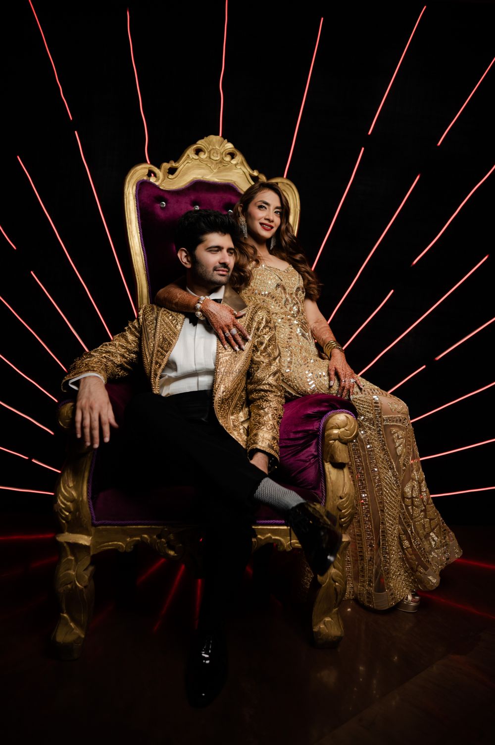 Photo of The bride and groom in co-ordinated gold outfits for a cocktail party