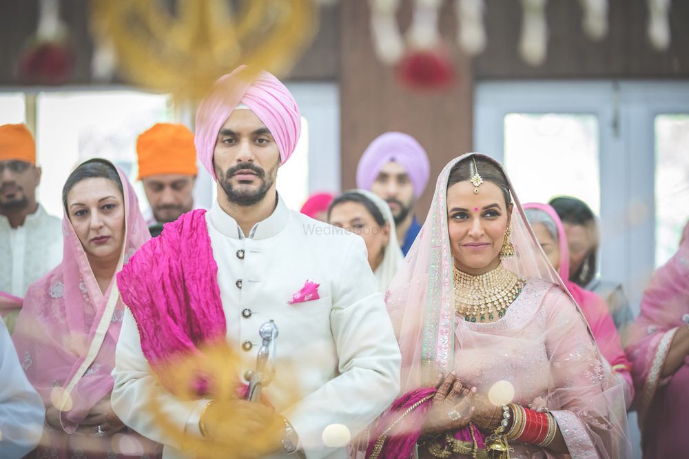 Photo of Celebrity couple Neha Dhupia and Angad Bediin color coordinated outfits at their anand karaj ceremony