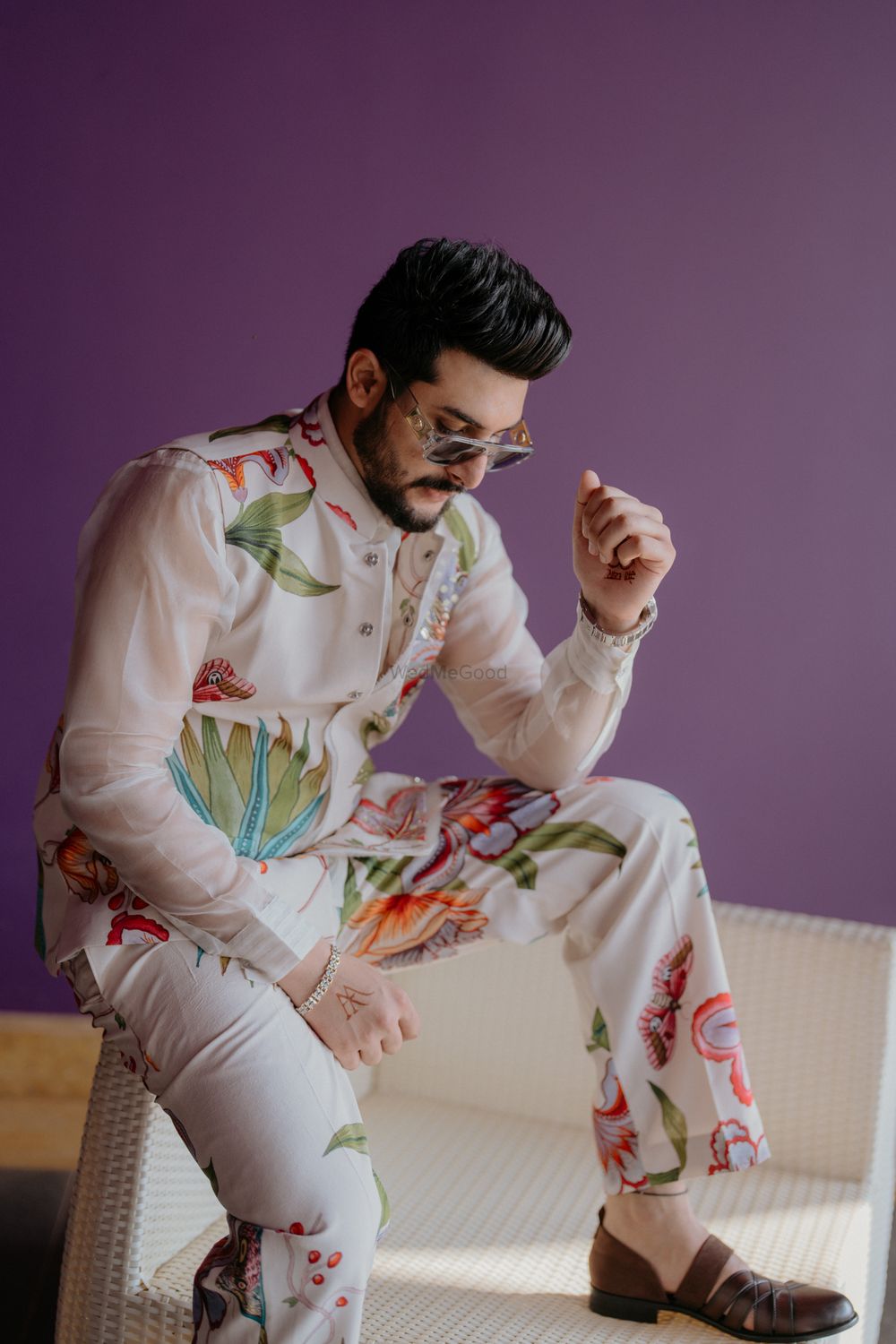 Photo of Stylish groom shot with the groom in a floral printed jacket set on his haldi