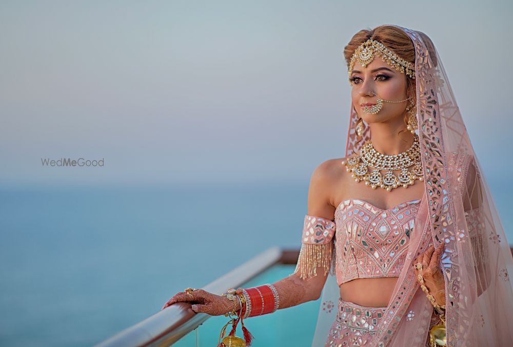 Photo of Bride dressed in pink lehenga posing on her wedding day.