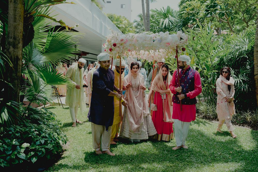 Photo of A bridal entry with the bride in a pink lehega, and under the phoolon ki chaadar!
