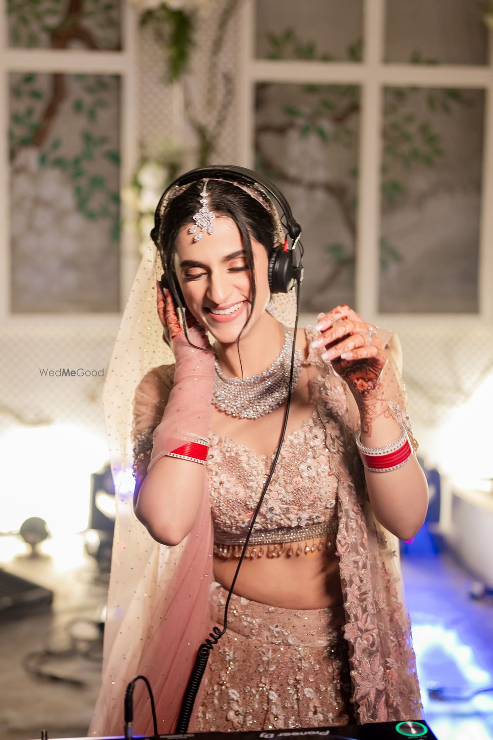 Photo of Fun bridal candid shot where she is enjoying herself at the DJ console on her wedding day