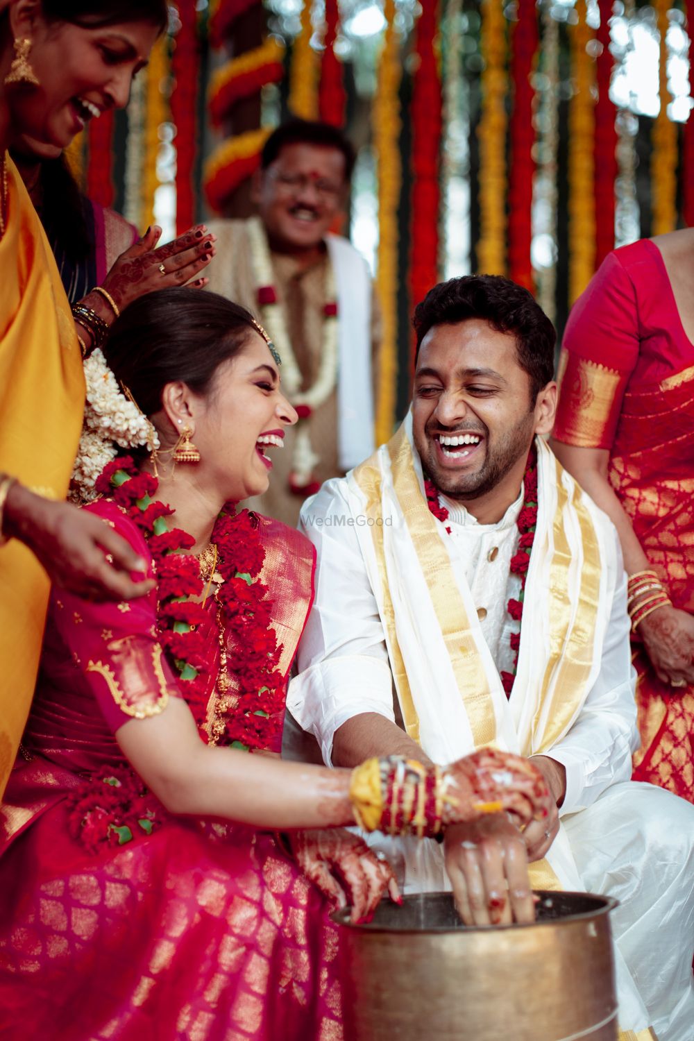 Photo of Happy South Indian couple smiling during their wedding rituals.