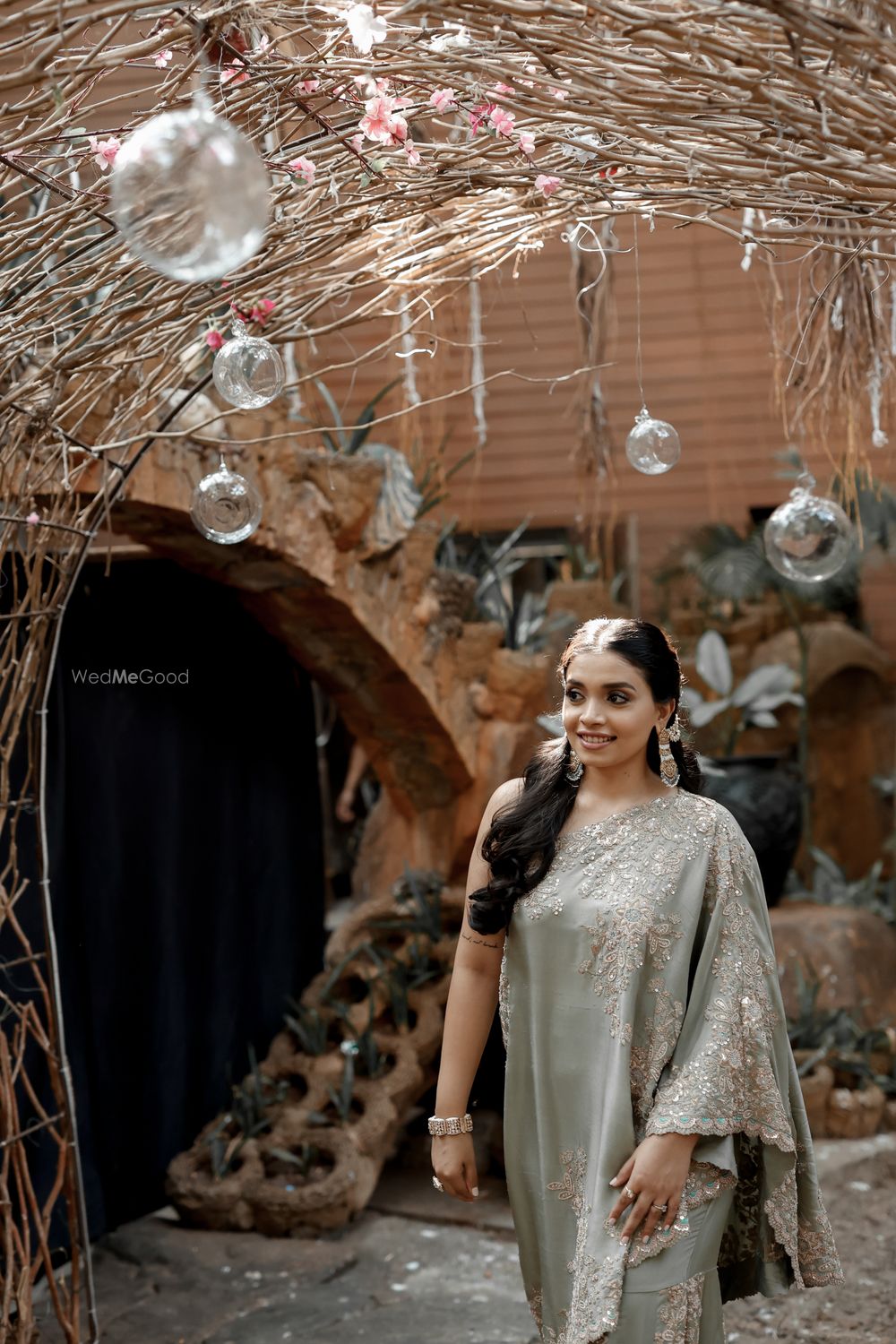 Photo of Bridal portrait with a stunning one shoulder outfit in grey with background decor in rustic style