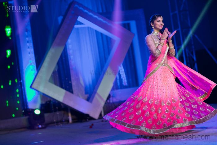 Photo of bright pink flowy sangeet lehenga with gold blouse