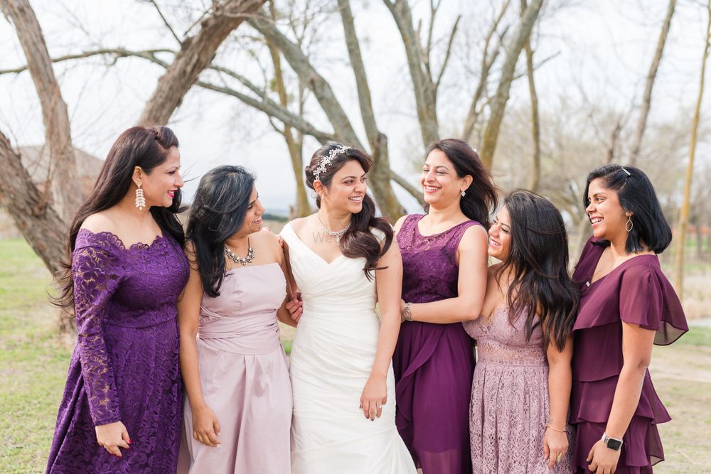 Photo of Bride with matching bridesmaids in purple