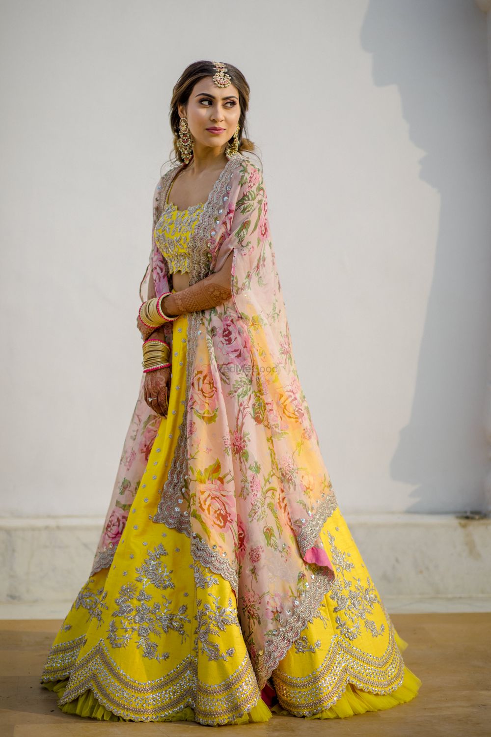 Photo of Bride wearing a yellow lehenga with a floral print dupatta